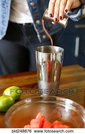 Woman pouring liquid into cocktail shaker View Large Photo Image Stock Photograph - Woman pouring liquid into cocktail shaker. Fotosearch