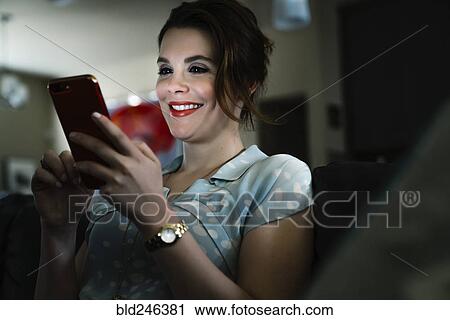 Woman texting on cell phone in the dark View Large Photo Image Stock Image - Woman texting on cell phone in the dark. Fotosearch