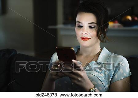 Woman texting on cell phone in the dark View Large Photo Image Stock Photo - Woman texting on cell phone in the dark. Fotosearch