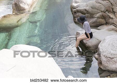 Woman wearing sun hat dangling feet in river View Large Photo Image Stock Image - Woman wearing sun hat dangling feet in river. Fotosearch