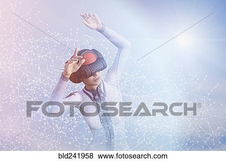 Stock Photo - Woman with arms raised using virtual reality helmet. Fotosearch