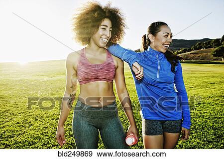 Stock Photo - Women laughing in sunny field. Fotosearch