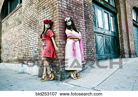 Stock Photo - Women on sidewalk corner wearing skull face paint. Fotosearch