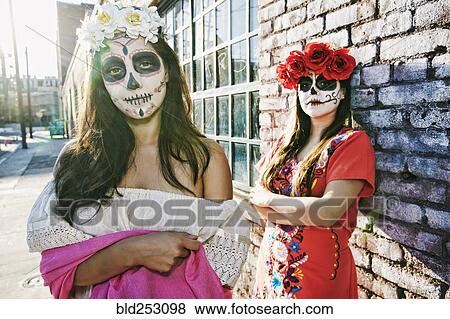Stock Photo - Women on sidewalk wearing skull face paint. Fotosearch