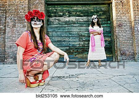 Stock Photography - Women on sidewalk wearing skull face paint. Fotosearch