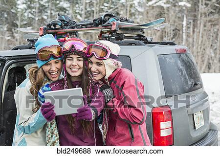 Stock Photo - Women posing for cell phone selfie in winter using digital tablet. Fotosearch