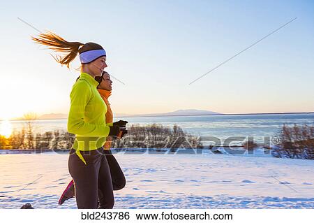 Stock Photograph - Women running on snow in winter. Fotosearch
