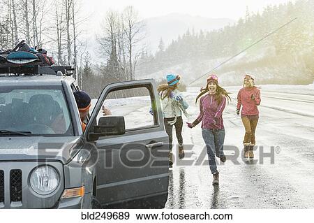 Women running to car in winter View Large Photo Image Stock Photo - Women running to car in winter. Fotosearch