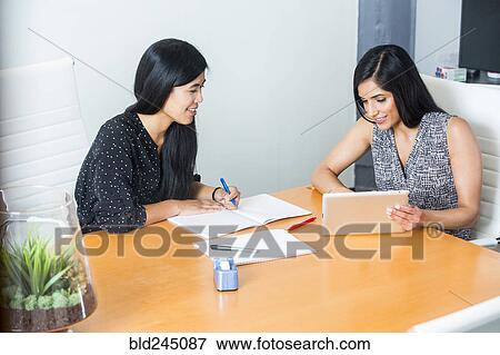 Women using digital tablet in meeting View Large Photo Image Stock Photo - Women using digital tablet in meeting. Fotosearch