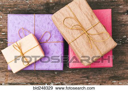 Stock Photo - Wrapped gifts on wooden table. Fotosearch
