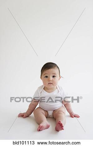 Stock Image - Asian baby girl sitting on floor. Fotosearch