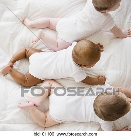 Babies laying on floor together View Large Photo Image Stock Photograph - Babies laying on floor together. Fotosearch