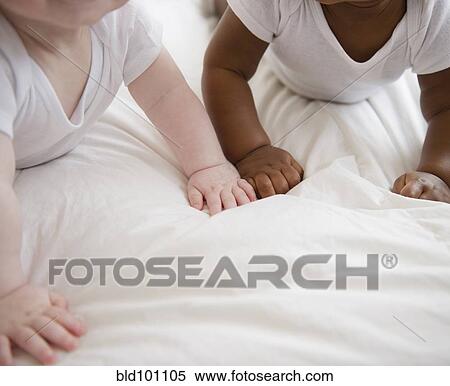Stock Photography - Babies laying on floor together. Fotosearch