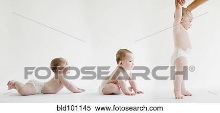Stock Photography - Babies laying, sitting and standing together. Fotosearch