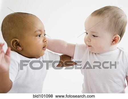 Babies looking at each other View Large Photo Image Stock Photo - Babies looking at each other. Fotosearch