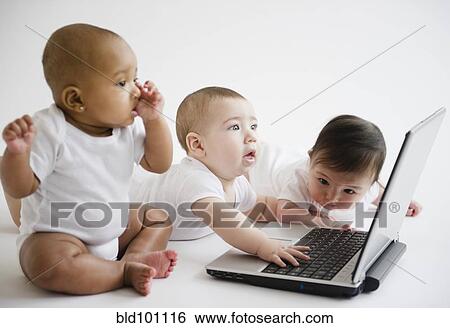Stock Photograph - Babies playing with laptop. Fotosearch