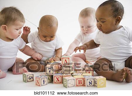 Stock Image - Babies sitting on floor playing with blocks. Fotosearch