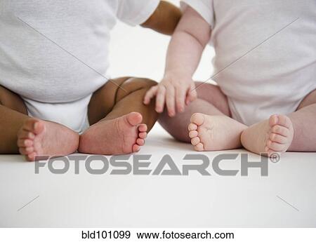 Stock Photo - Babies sitting on floor. Fotosearch