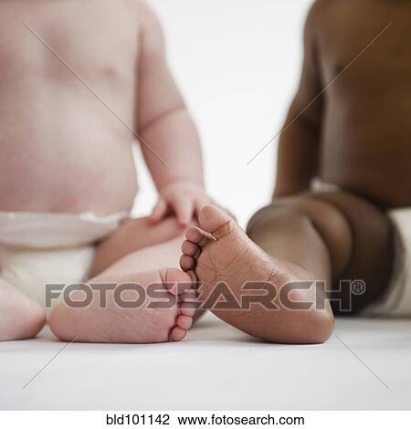 Stock Image - Babies sitting on floor together. Fotosearch