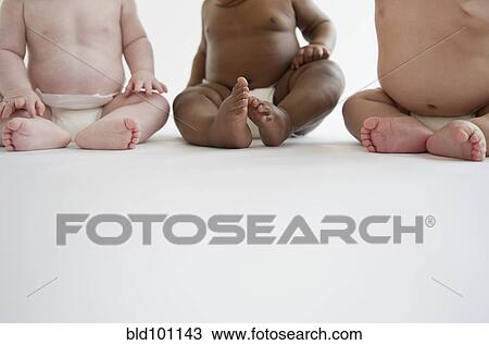 Stock Image - Babies sitting on floor together. Fotosearch