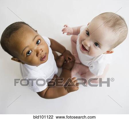 Babies sitting together on floor View Large Photo Image Stock Image - Babies sitting together on floor. Fotosearch