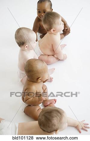 Stock Photo - Babies sitting together on floor. Fotosearch