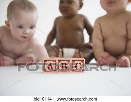 Stock Image - Babies sitting with alphabet blocks. Fotosearch