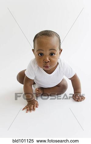 Stock Photography - Black baby boy crawling on floor. Fotosearch