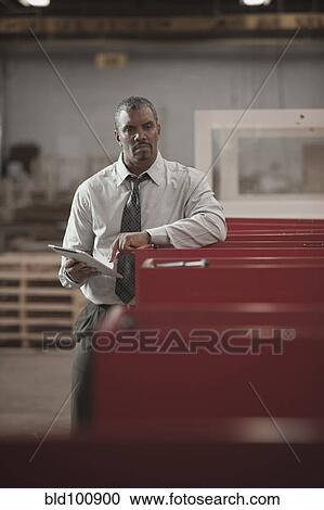 Black businessman using digital tablet in warehouse View Large Photo Image Stock Image - Black businessman using digital tablet in warehouse. Fotosearch