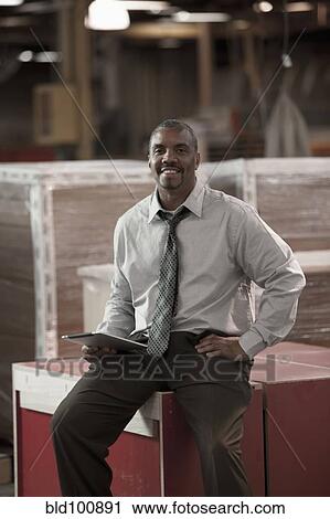 Black businessman working in warehouse View Large Photo Image Stock Image - Black businessman working in warehouse. Fotosearch