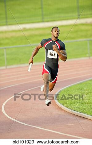 Stock Photo - Black runner carrying baton in relay race. Fotosearch