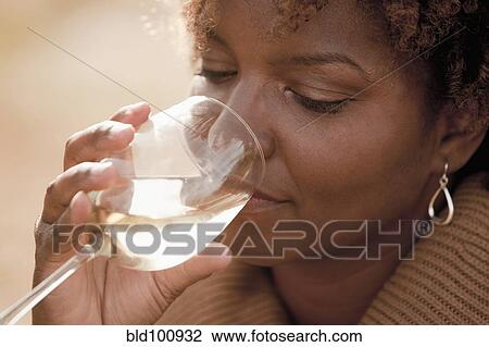 Stock Image - Black woman drinking wine. Fotosearch