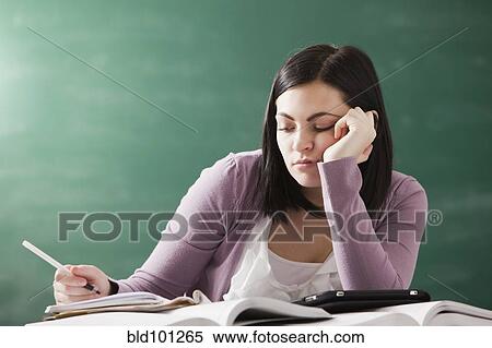 Stock Photography - Bored Caucasian student doing homework. Fotosearch
