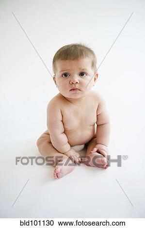 Stock Image - Caucasian baby boy sitting on floor. Fotosearch