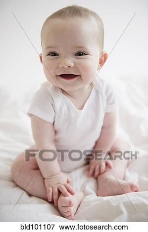 Stock Photo - Caucasian baby girl sitting on floor. Fotosearch