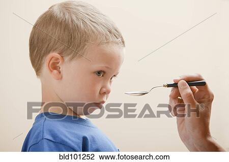 Stock Image - Caucasian boy taking medicine. Fotosearch
