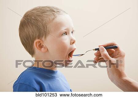 Stock Image - Caucasian boy taking medicine. Fotosearch