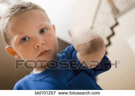 Stock Photo - Caucasian boy with bandage on elbow. Fotosearch