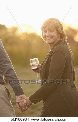 Picture - Caucasian couple drinking wine outdoors. Fotosearch