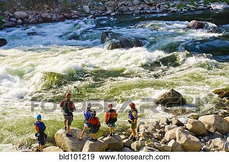 Stock Photo - Caucasian family standing near rapids in river. Fotosearch