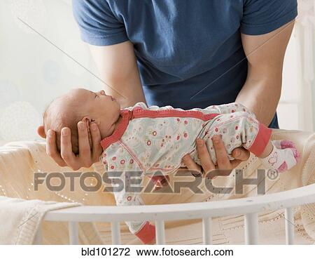 Caucasian father lifting baby girl from crib View Large Photo Image Stock Image - Caucasian father lifting baby girl from crib. Fotosearch