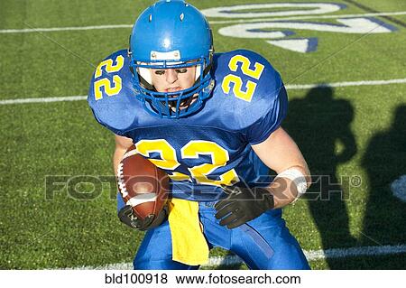 Stock Photo - Caucasian football player running with ball. Fotosearch