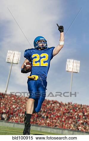 Stock Photography - Caucasian football player running with ball. Fotosearch