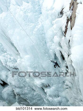 Picture - Caucasian man climbing ice. Fotosearch