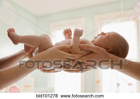 Stock Photo - Caucasian mother and father holding baby girl. Fotosearch