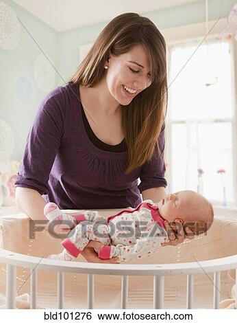 Caucasian mother lifting baby girl from crib View Large Photo Image Stock Photograph - Caucasian mother lifting baby girl from crib. Fotosearch