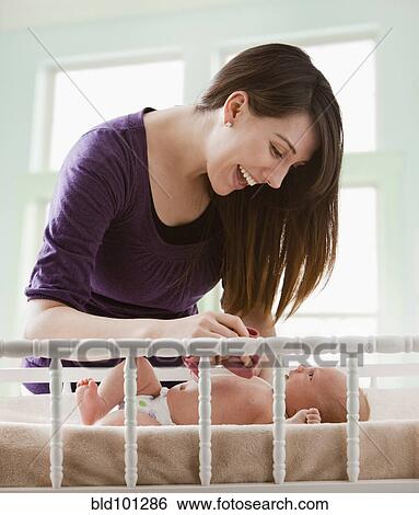 Stock Photograph - Caucasian mother looking at baby girl. Fotosearch
