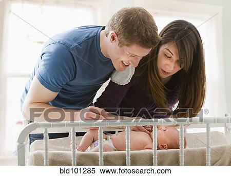 Caucasian parents looking at baby girl View Large Photo Image Stock Photography - Caucasian parents looking at baby girl. Fotosearch