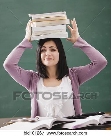 Caucasian student balancing books on head View Large Photo Image Stock Photo - Caucasian student balancing books on head. Fotosearch