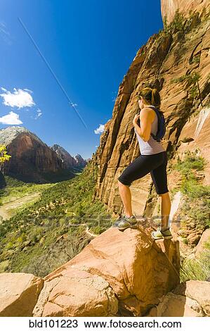 Stock Image - Caucasian woman hiking in canyon. Fotosearch